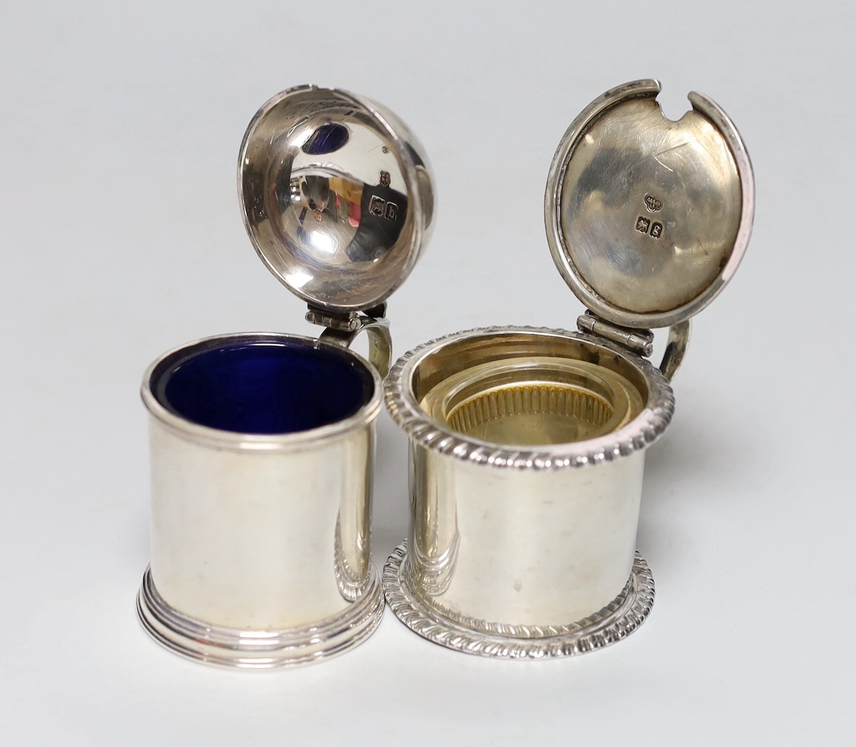 A late Victorian silver dome topped mustard pot, Josiah Williams & Co, London, 1897, height 8cm and an Edwardian silver drum mustard, London, 1902, 8.1oz, both with glass liners, one associated.